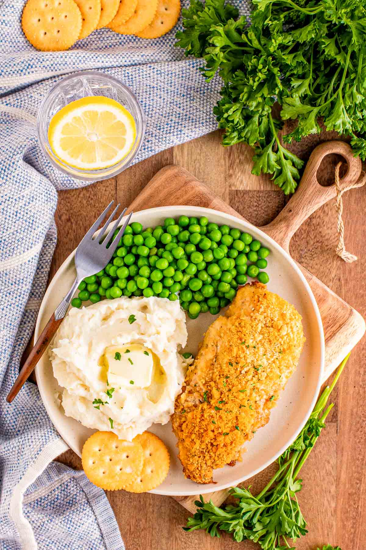 Overhead photo of a dinner plate with mashed potatoes, peas, and ritz cracker chicken breast.