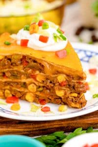 Close up of a slice of taco pie on a white and blue plate.