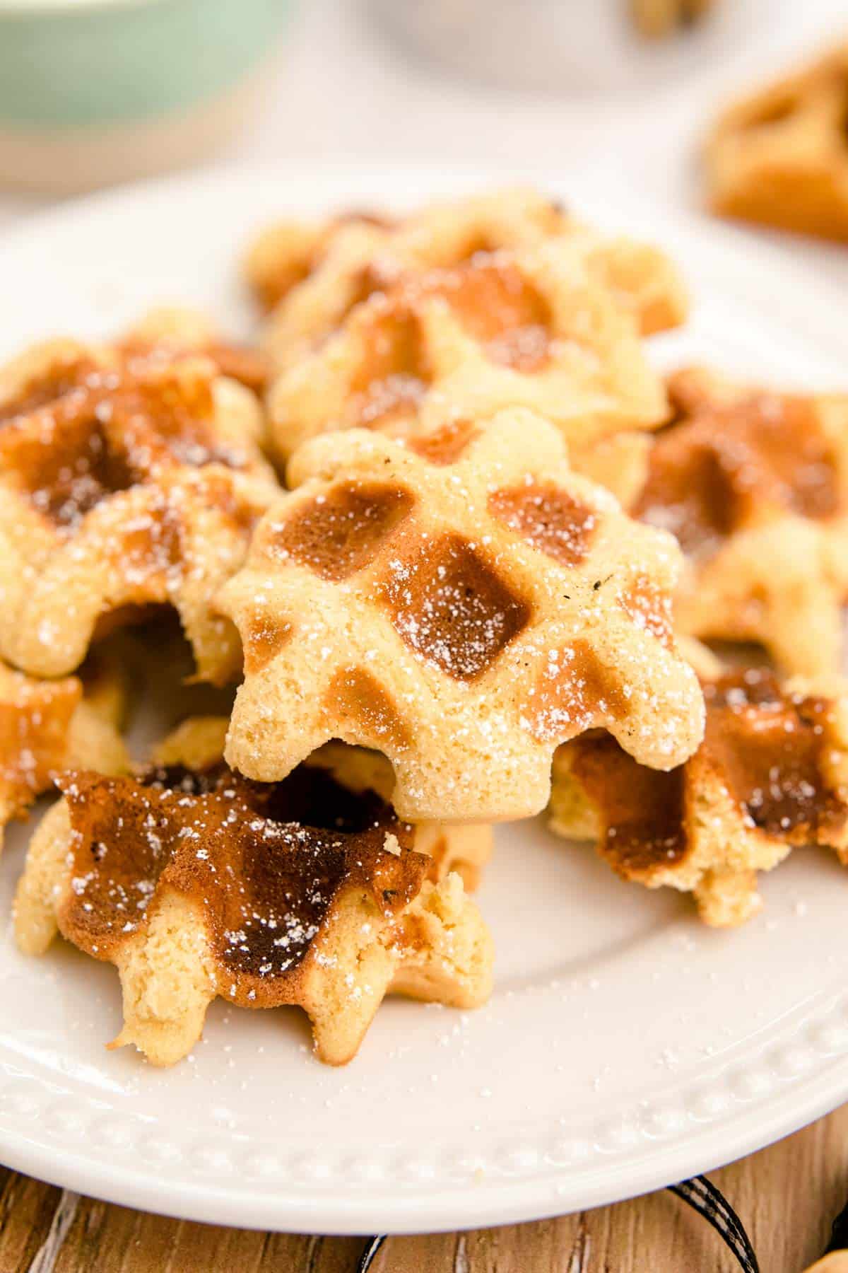 Close up photo of waffle cookies on a white plate.