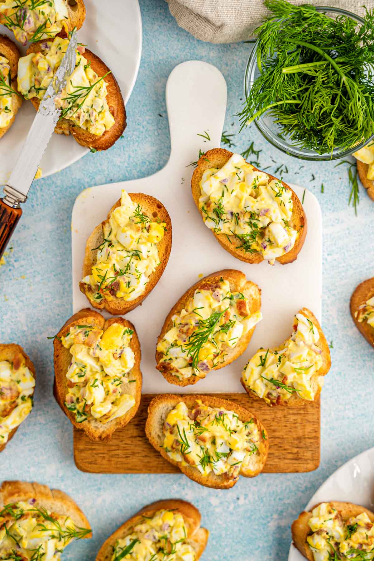 Overhead photo of bacon egg salad crostinis on a serving board.