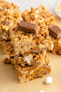 A stack of three biscoff rice krispie treats on a piece of parchment paper.