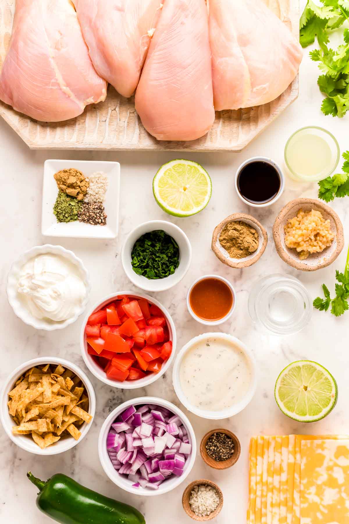 Overhead photo of ingredients prepped to make fiesta lime chicken on a white counter.
