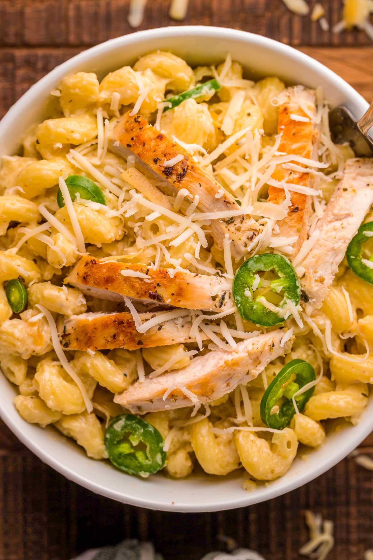 A white bowl with rattlesnake pasta (creamy spicy chicken pasta).