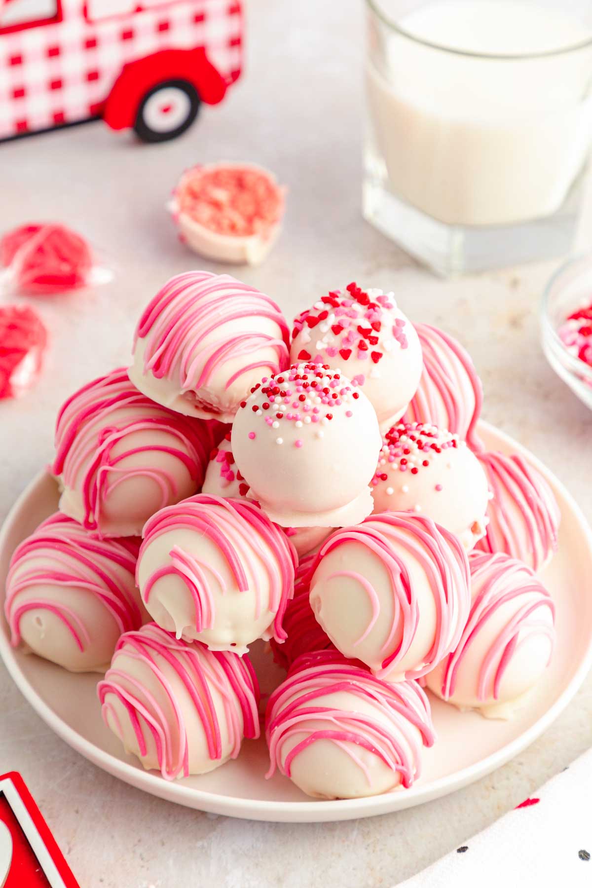 Strawberry cake balls on a white plate.