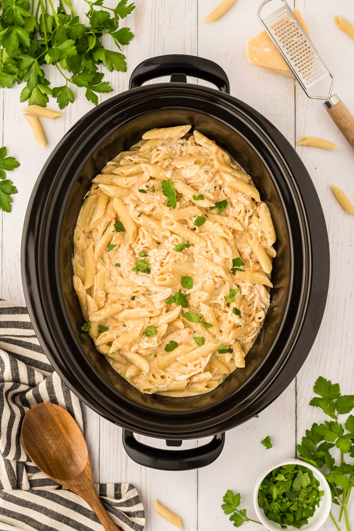Overhead photo of creamy garlic chicken parmesan pasta in a crockpot.