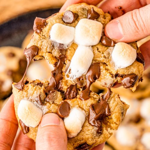 A woman's hand pulling a s'mores cookie in half.