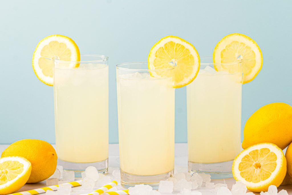 Three glasses of lemonade on a table.