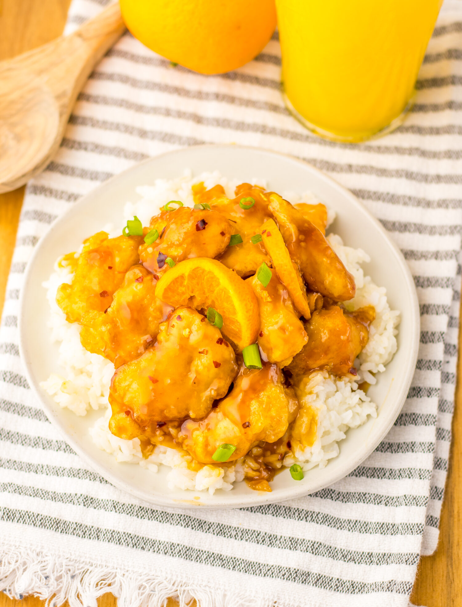 orange chicken on a plate of rice. 